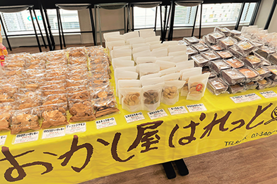 おかし屋ぱれっとのロゴが印刷された敷布の上に、たくさんのお菓子が並んでいるイメージ